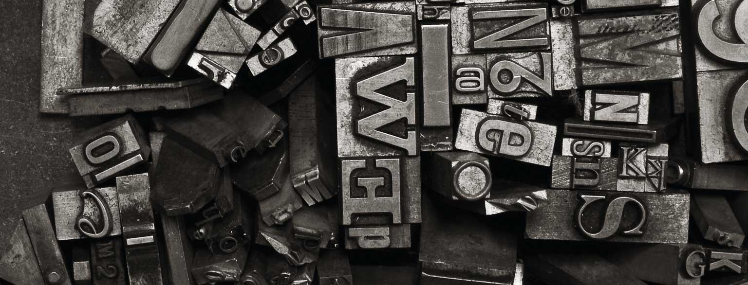 Masthead Graphic: A variety of metal type sorts for handset letterpress printing in a resorting tray.