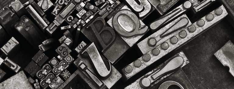 Masthead Graphic: A variety of metal type sorts for handset letterpress printing in a resorting tray.
